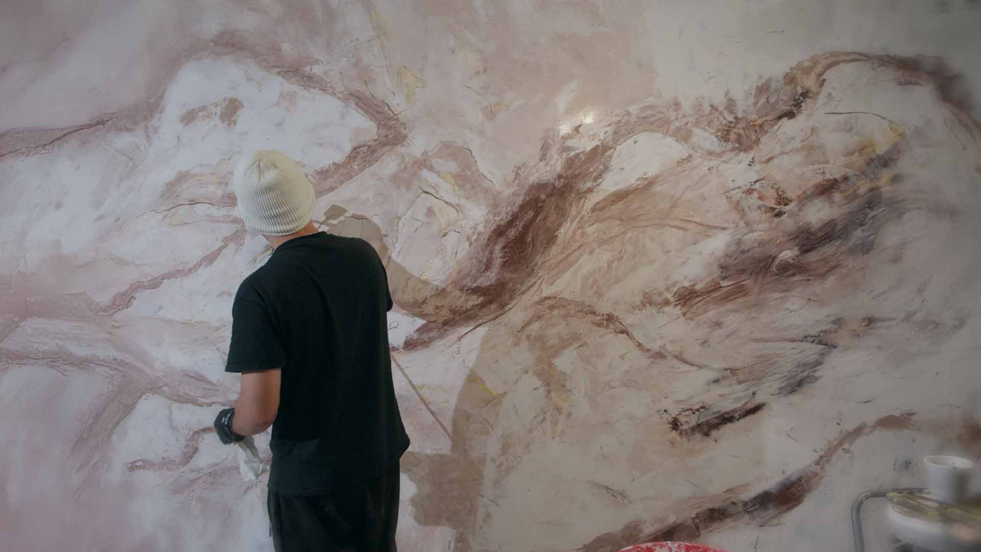 Troweling a rosé-marble wall