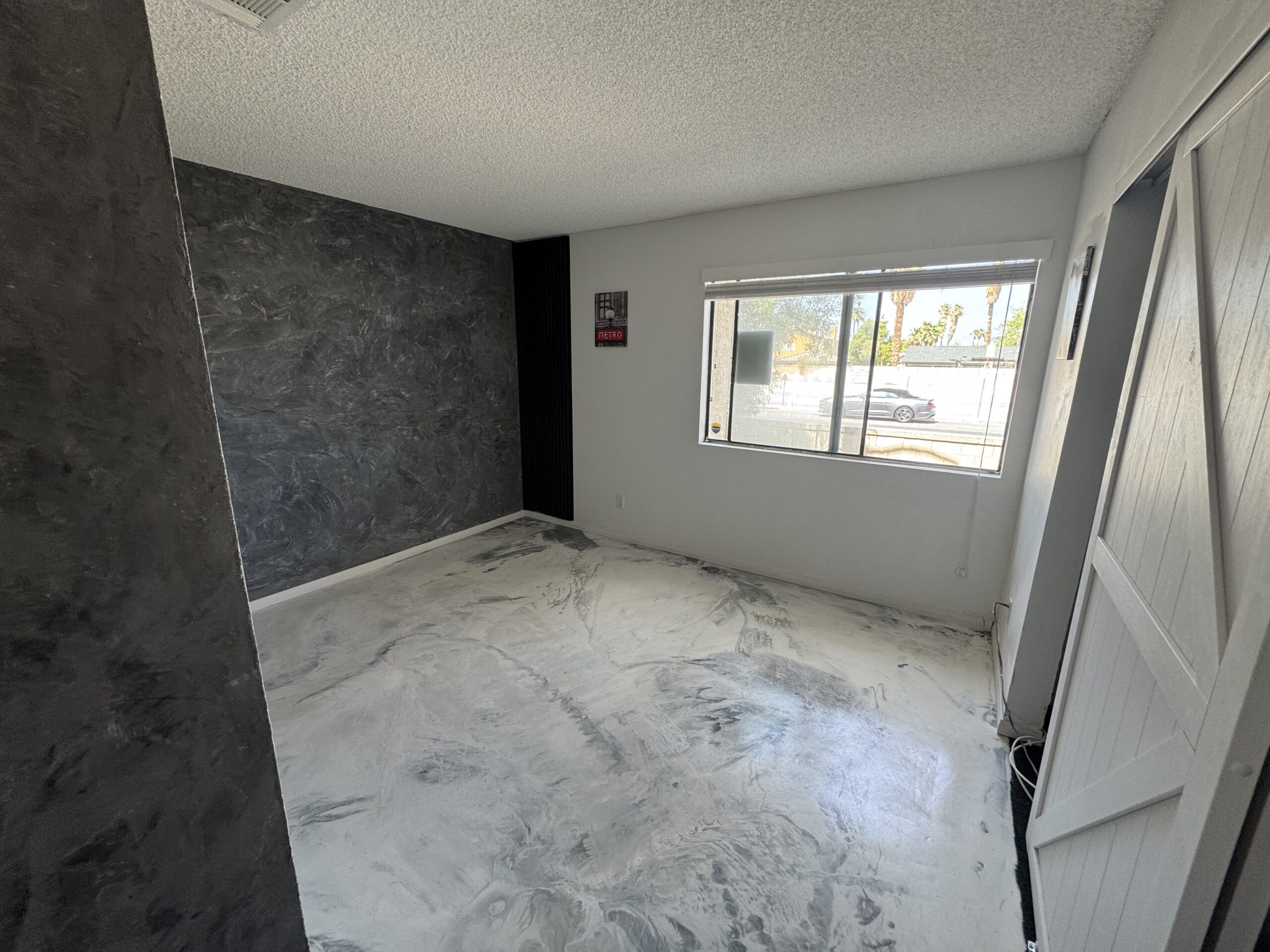 Charcoal plaster wall, metallic epoxy floor