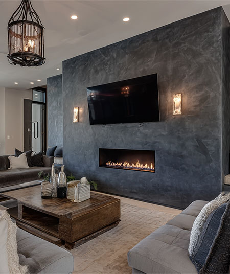 Charcoal Venetian plaster feature wall with a linear fireplace and sconces