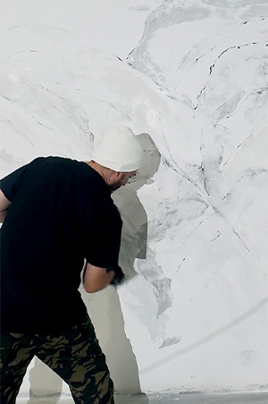 Hand-troweling a marble plaster finish onto a wall